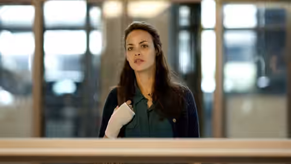 Marie (Bérénice Bejo) with a bandaged hand standing in a bright hallway