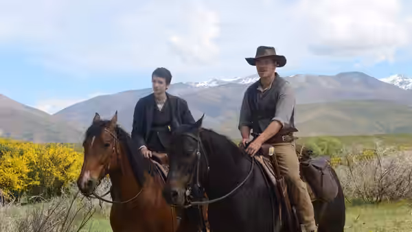 Jay Cavendish (Kodi Smit-McPhee) and Silas (Michael Fassbender) riding horses in the mountains