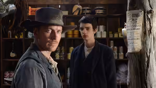 Silas (Michael Fassbender) and Jay Cavendish (Kodi Smit-McPhee) standing in a general store
