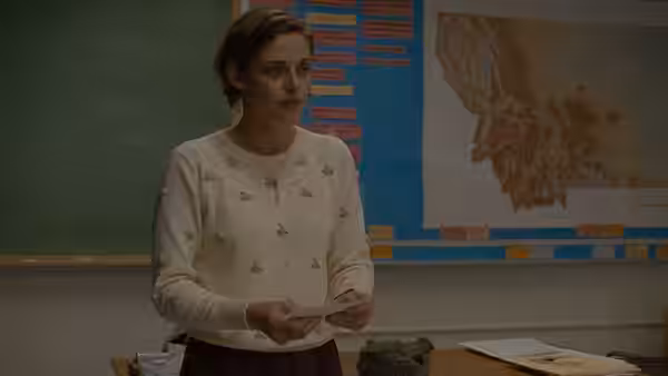 Elizabeth Travis (Kristen Stewart) holding papers while standing in a classroom