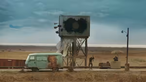 figures stand near a van and large damaged billboard in the desert