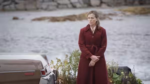Olive Kitteridge (Frances McDormand) standing beside a car near the water