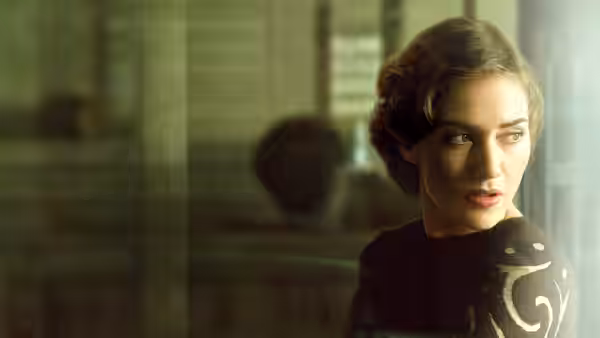 Mildred Pierce (Kate Winslet) gazing ahead with a serious expression