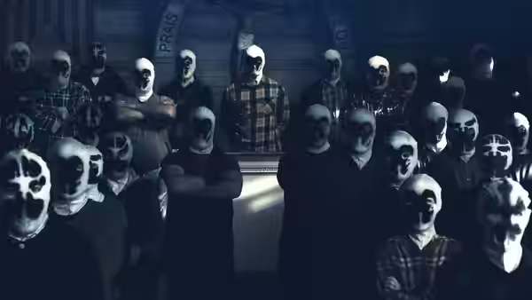 Group of masked figures in white hoods gathered inside a wooden hall with crucifix