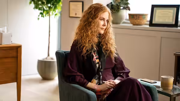 Grace Fraser (Nicole Kidman) sits in an armchair in a bright office