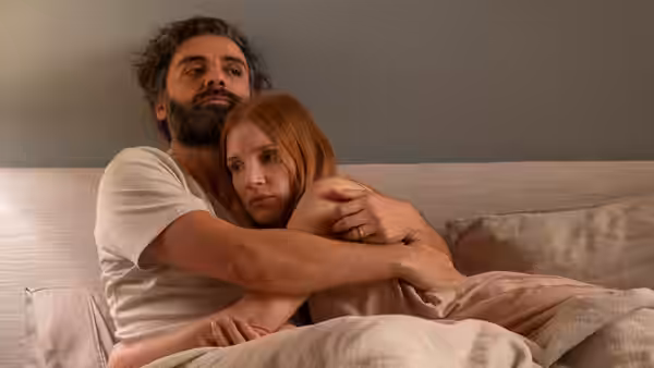 Jonathan (Oscar Isaac) embracing Mira (Jessica Chastain) while lying in bed