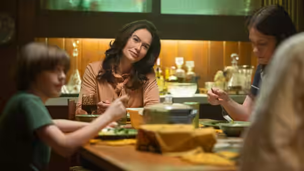 Dorothy Hunt (Lena Headey) sits at a dinner table with a boy and two others