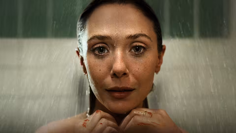 Candy Montgomery (Elizabeth Olsen) under running water hands clasped near her chin