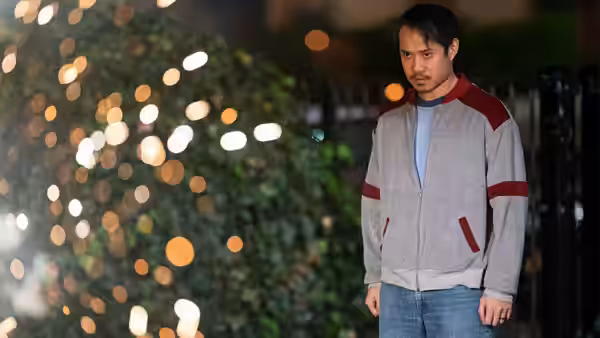 Young man in zip-up jacket standing outdoors at night