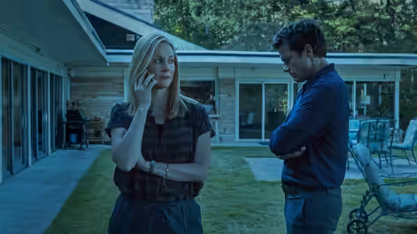 Wendy Byrde (Laura Linney) talks on the phone while Marty Byrde (Jason Bateman) watches