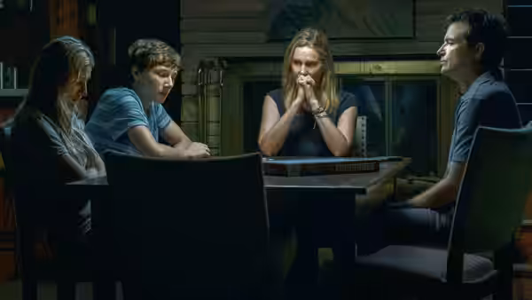 The Byrde family sits around a table in a dimly lit room