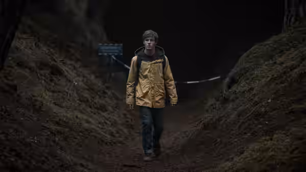 Jonas Kahnwald (Louis Hofmann) walking out of a dark tunnel