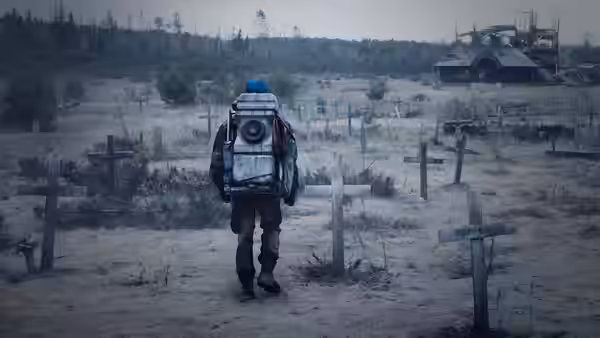 Figure with large backpack walks through a barren graveyard of crosses