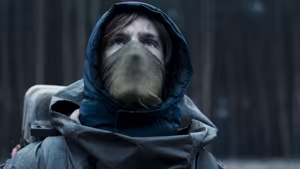 Young man in hooded winter gear and mask looks upward
