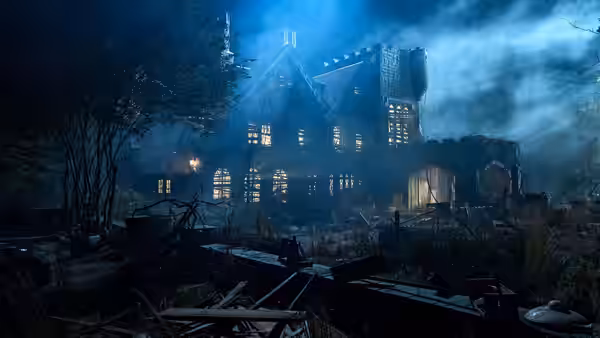 A crumbling mansion glows with interior lights through nighttime fog