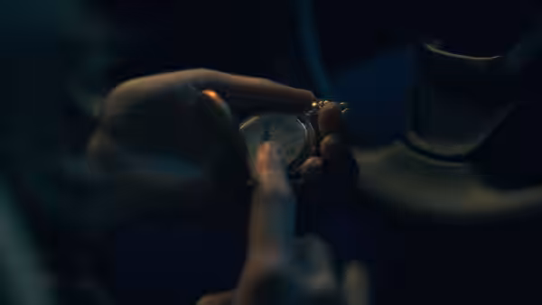 Hands hold a pocket watch while pointing at its face