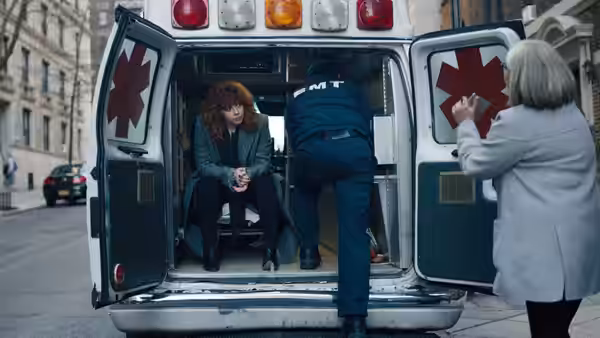 Nadia (Natasha Lyonne) seated inside an open ambulance beside a paramedic