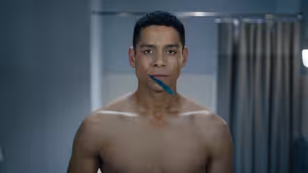 Alan (Charlie Barnett) brushing his teeth shirtless in a tiled bathroom