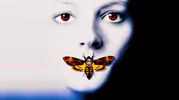 Close-up of a woman's face with a death's-head moth over her mouth