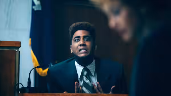 Young man in suit and tie speaking in a courtroom