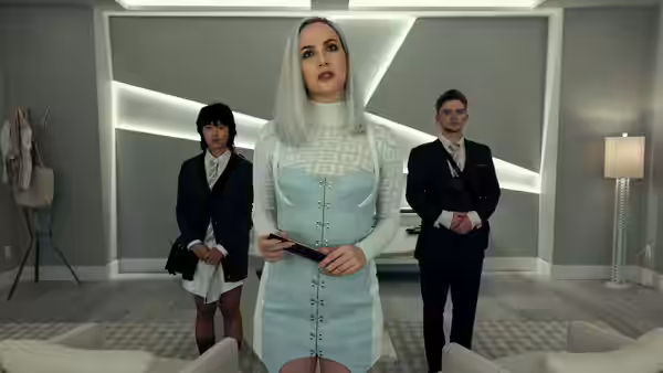 A woman in light blue dress holds a handgun in a sleek modern room