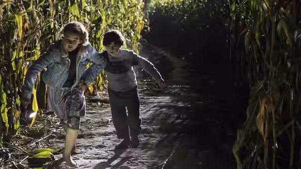 Regan Abbott (Millicent Simmonds) and Marcus Abbott (Noah Jupe) running in a cornfield