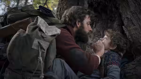 Lee Abbott (John Krasinski) holding Marcus Abbott (Noah Jupe) in the woods