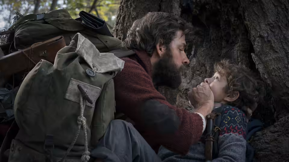 Lee Abbott (John Krasinski) holding Marcus Abbott (Noah Jupe) in the woods
