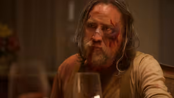 Rob Feld (Nicolas Cage), bruised and bloodied, sits at a restaurant table
