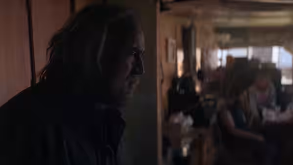 Rob Feld watches from a dim doorway as diners sit in a restaurant