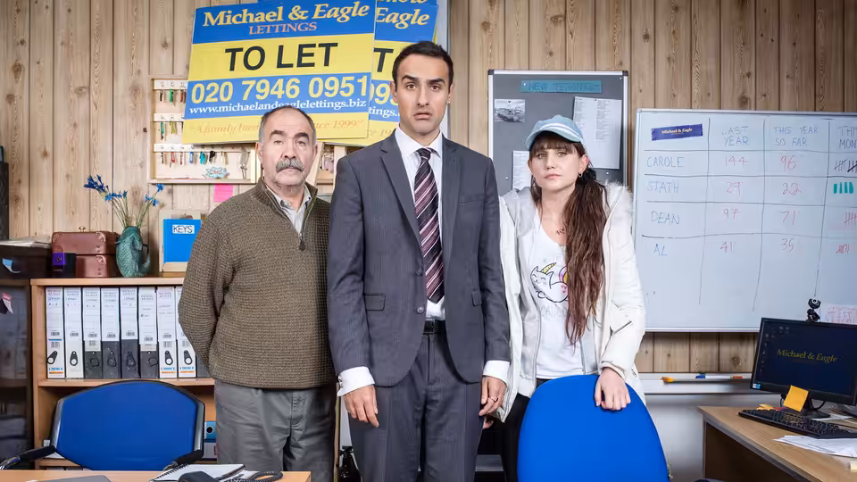 Vasos Charalambos (Christos Stergioglou), Stath Charalambos (Jamie Demetriou) and Sophie Charalambos (Natasia Demetriou) stand in an office