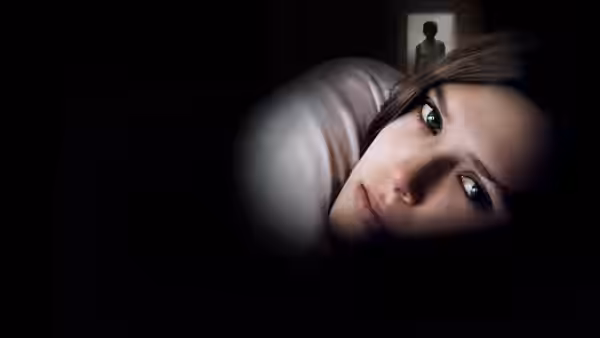 Martha (Elizabeth Olsen) lies on the floor looking upward in a dark room