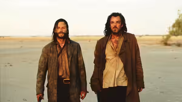 Arthur Burns and Charlie Burns stand together on a barren stretch of open country