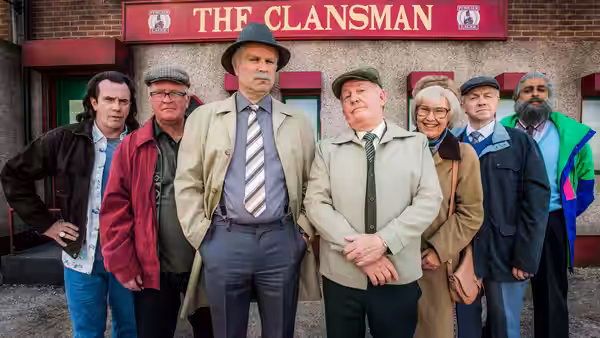 Group of adults standing outside The Clansman pub entrance
