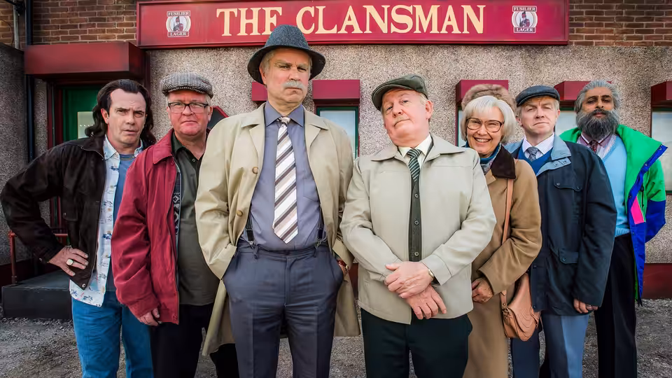 Group of adults standing outside The Clansman pub entrance
