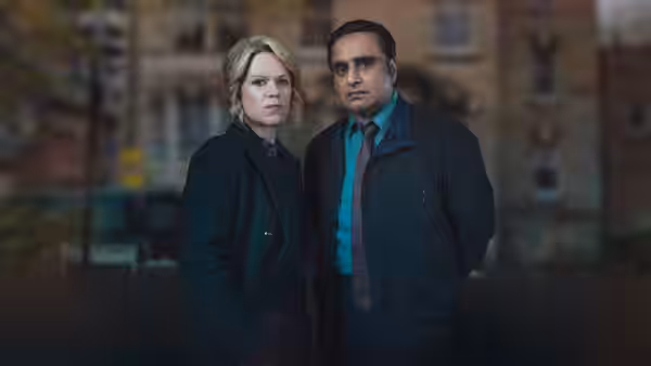A blonde woman and DS Sunny Khan (Sanjeev Bhaskar) standing together on a city street