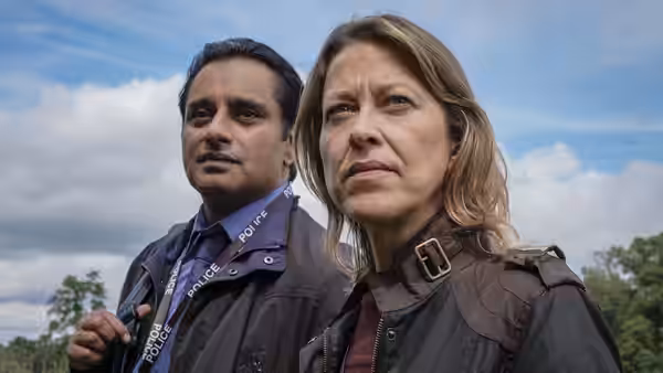 DCI Cassie Stuart (Nicola Walker) and DS Sunny Khan (Sanjeev Bhaskar) standing side by side outdoors