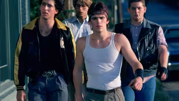 Rusty James (Matt Dillon) walks down the street with several friends behind him