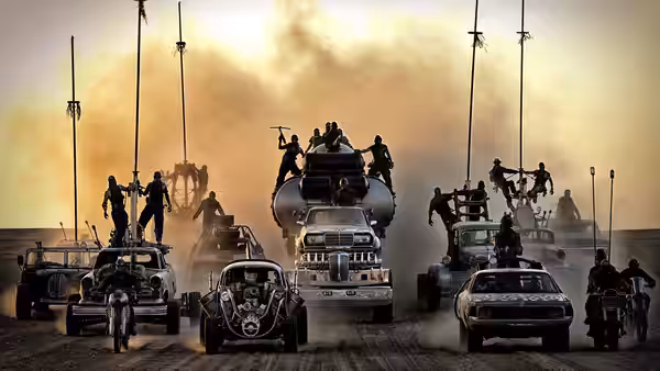 A convoy of armoured vehicles crosses the desert at sunset