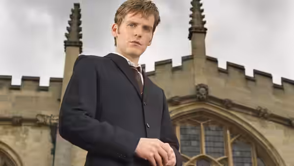 DC Endeavour Morse standing before a historic stone building with spires