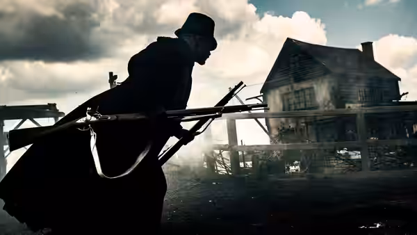 James Keziah Delaney (Tom Hardy) carrying rifles before a wooden house