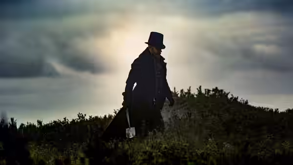 James Keziah Delaney (Tom Hardy) walking on a hill with an axe