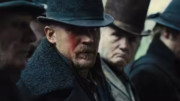 James Keziah Delaney (Tom Hardy) with blood on his face among other men