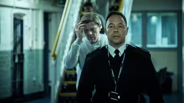 Stephen Graham as Eric McNally stands in a stairwell with Sean Bean behind