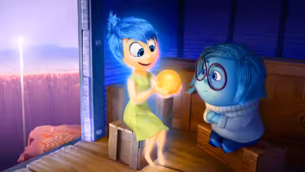 Joy holding a glowing memory orb while speaking to Sadness on a wooden platform