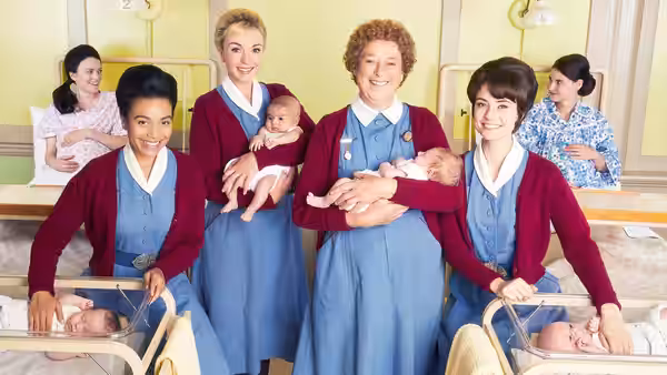 Group of nurses holding newborns in a hospital maternity ward