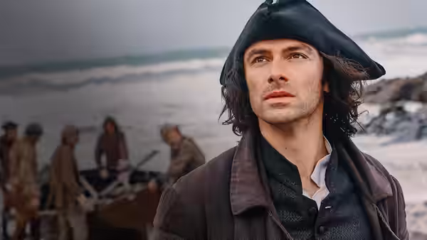Ross Poldark (Aidan Turner) stands on a beach wearing a tricorn hat