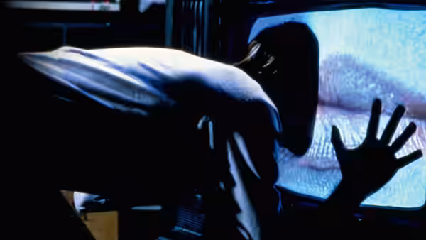a man in a white shirt leaning toward a television screen showing lips