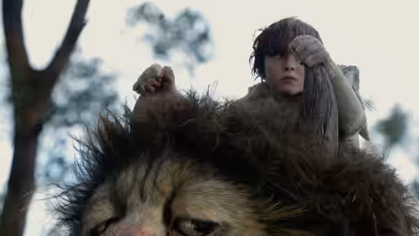 Max riding on the shoulders of a large furry creature outdoors