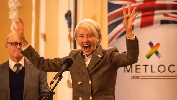Vivienne Rook (Emma Thompson) raises her arms in celebration at a podium